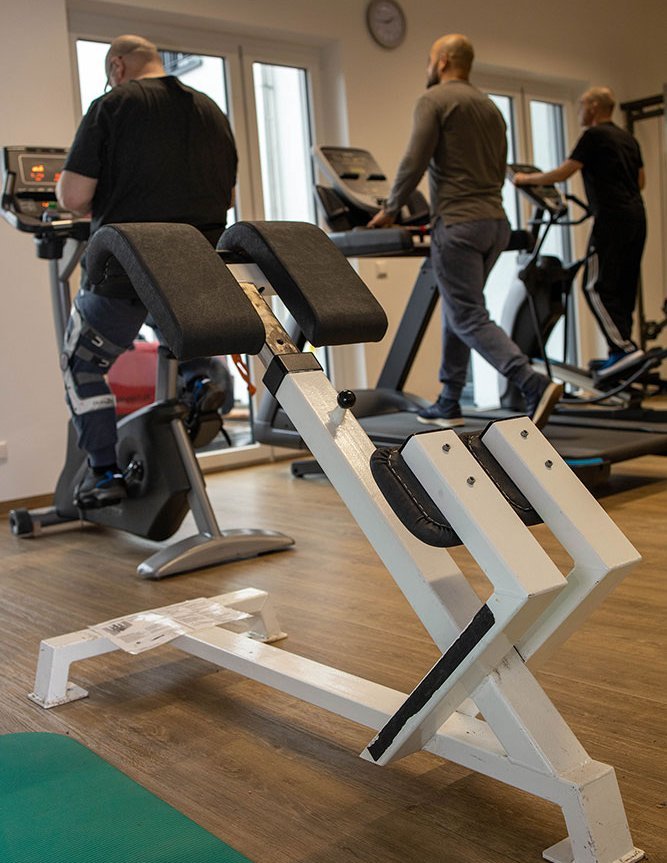 Sportraum: Männer auf dem Crosstrainer