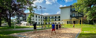 Aussenaufnahme der Suchthilfe mit großem Garten und Volleyball-Anlage