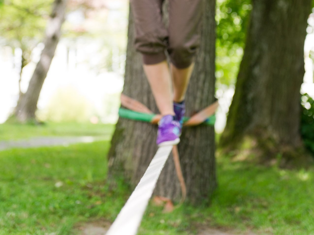 Nahaufnahme: eine junge Frau auf der Slackline