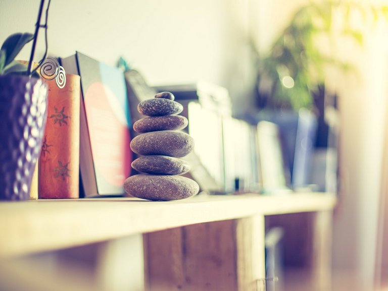 Nahaufnahme: im Bücherregal steht ein "Steinturm"