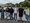 Sechs Personen stehen nebeneinander auf einer Brücke und posieren für ein Foto. Im Hintergrund ist eine Stadt mit einer markanten Festung auf einem Hügel über einem Fluss zu sehen.