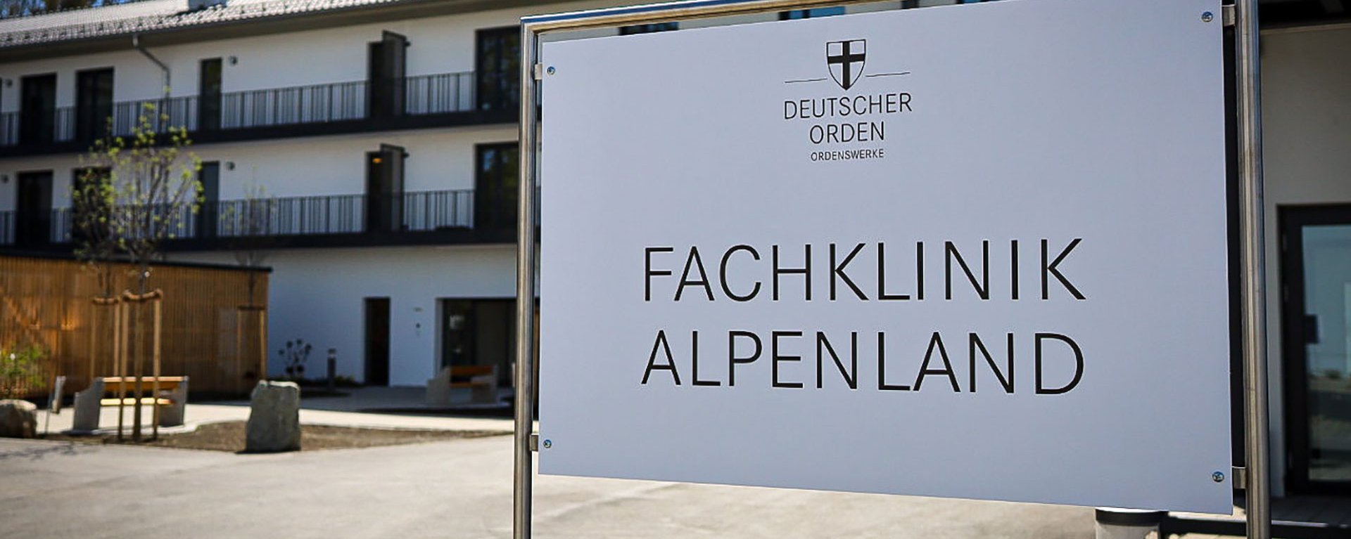 Aussenaufnahme der Einrichtung - Schild mit Aufschrift: "Deutscher Orden - FACHKLINIK ALPENLAND"