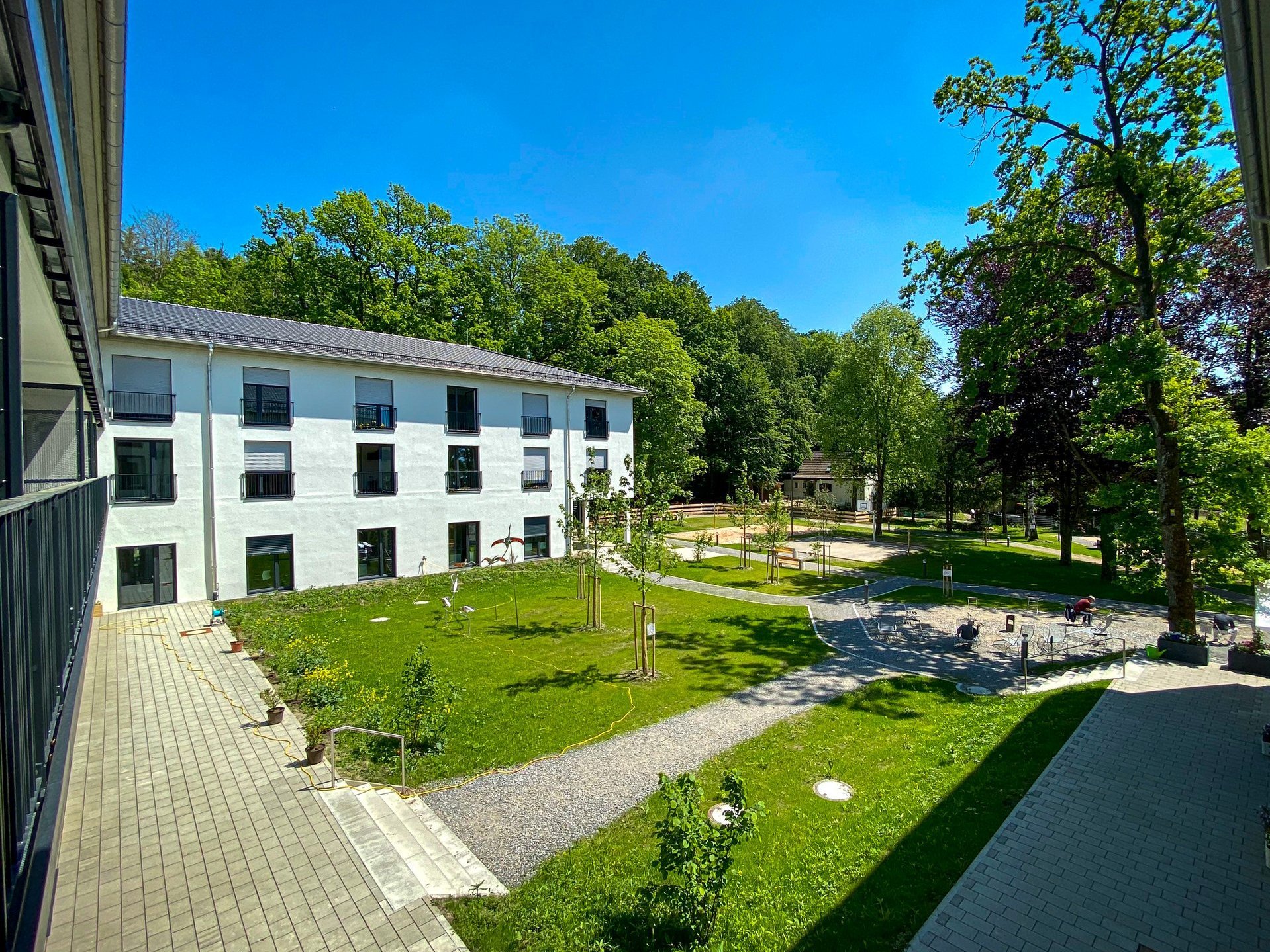 Gartenanlage der Suchthilfe vom Balkon aus fotografiert - viel Grün und Bäume